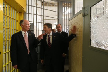 Alabama Gov. Robert Bentley, right, looks at broken glass as he tours a portion of William C. Holman Correctional facility in Atmore, Ala., Tuesday, March 15, 2016 with Alabama Department of Corrections Commissioner Jeff Dun, center, and state Sen. Cam Ward. Two disturbances that have occurred in the last three days at the maximum security prison designed to house 637 inmates. The current population at Holman is 991, which is 156% of design capacity. (Alabama GovernorÕs Office, Jamie Martin)