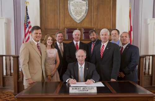 Alabama Gov. Robert Bentley ceremonially signs SB 90, the Apprenticeship Tax Credit Act (Act 2016-314), and passes pens to the bill's supporters, at the state Capitol, Tuesday, July 26, 2016. The bill was sponsored by Sen. Arthur Orr and Rep. Alan Baker. (Governor's Office, Sydney A. Foster)