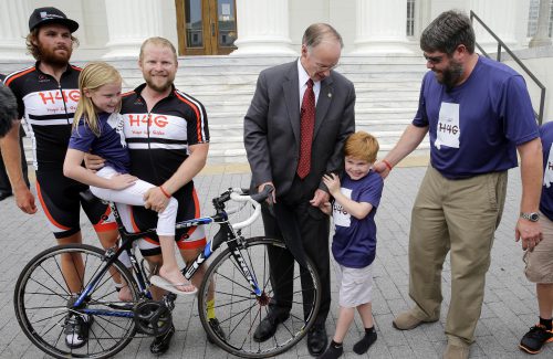 Alabama Governor Robert Bentley holds hands with nine-year-old Gabe Griffin, a nine-year-old boy who was born with Duchennne Muscular Dystrophy (DMD) as the Ride4Gabe group made a stop in Montgomery on Monday, August 11, 2014. Pictured from left are Wes Bates, Addie Griffin, Michael Staley, Governor Bentley, Gabe Griffin and Scott Griffin. DMD is a genetic mutation that brings with it weakness and muscle degeneration. It is the most common form of muscular dystrophy in children, affecting boys almost exclusively. The Ride4Gabe cyclists started their trek in Oregon, and will ride to Mobile to promote awareness and raise funds for research of the disease.